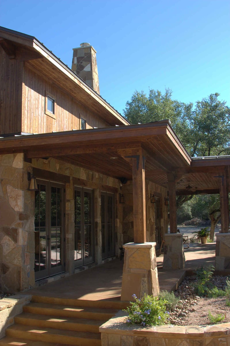 Covered porch with stone pillars on a custom home by J Bryant Boyd in Georgetown, TX