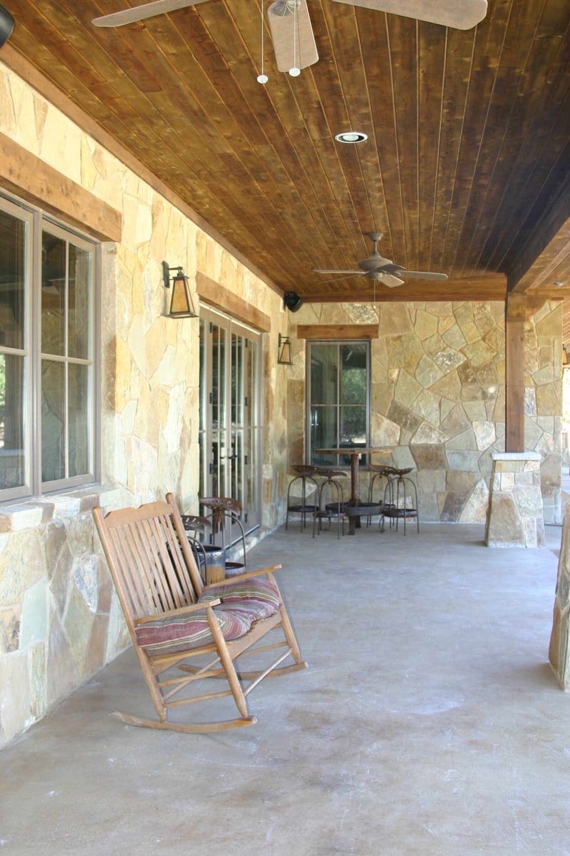 Covered porch with wooden ceiling in a custom home by J Bryant Boyd in Georgetown, TX