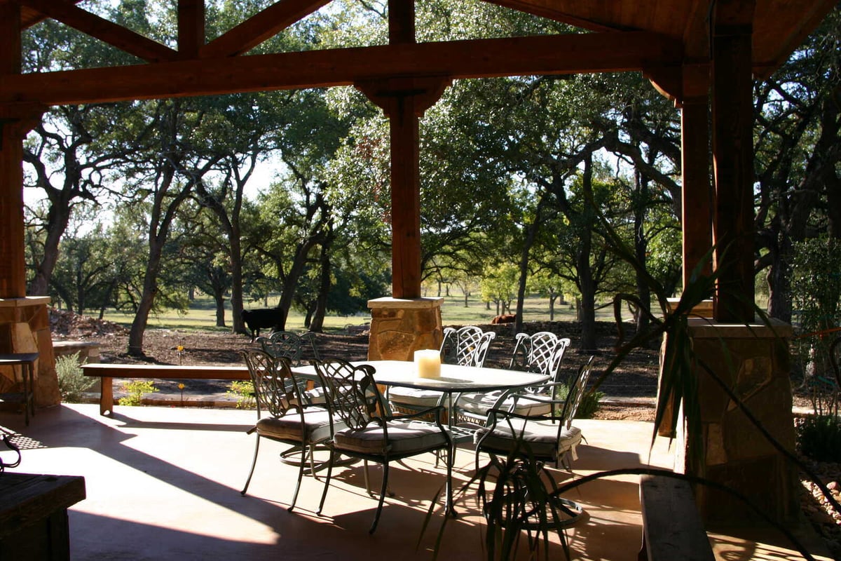 Outdoor dining area under a covered patio in a custom home by J Bryant Boyd in Georgetown, TX