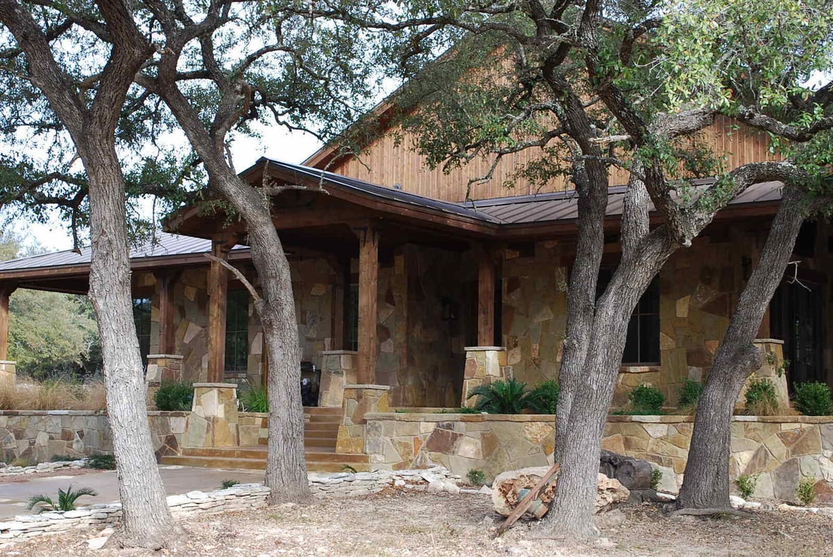 Rustic exterior of a custom stone home by J Bryant Boyd in Georgetown, TX
