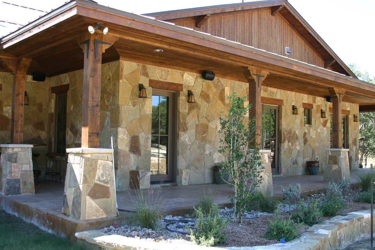 Stone exterior and landscaped yard of a custom home by J Bryant Boyd in Georgetown, TX