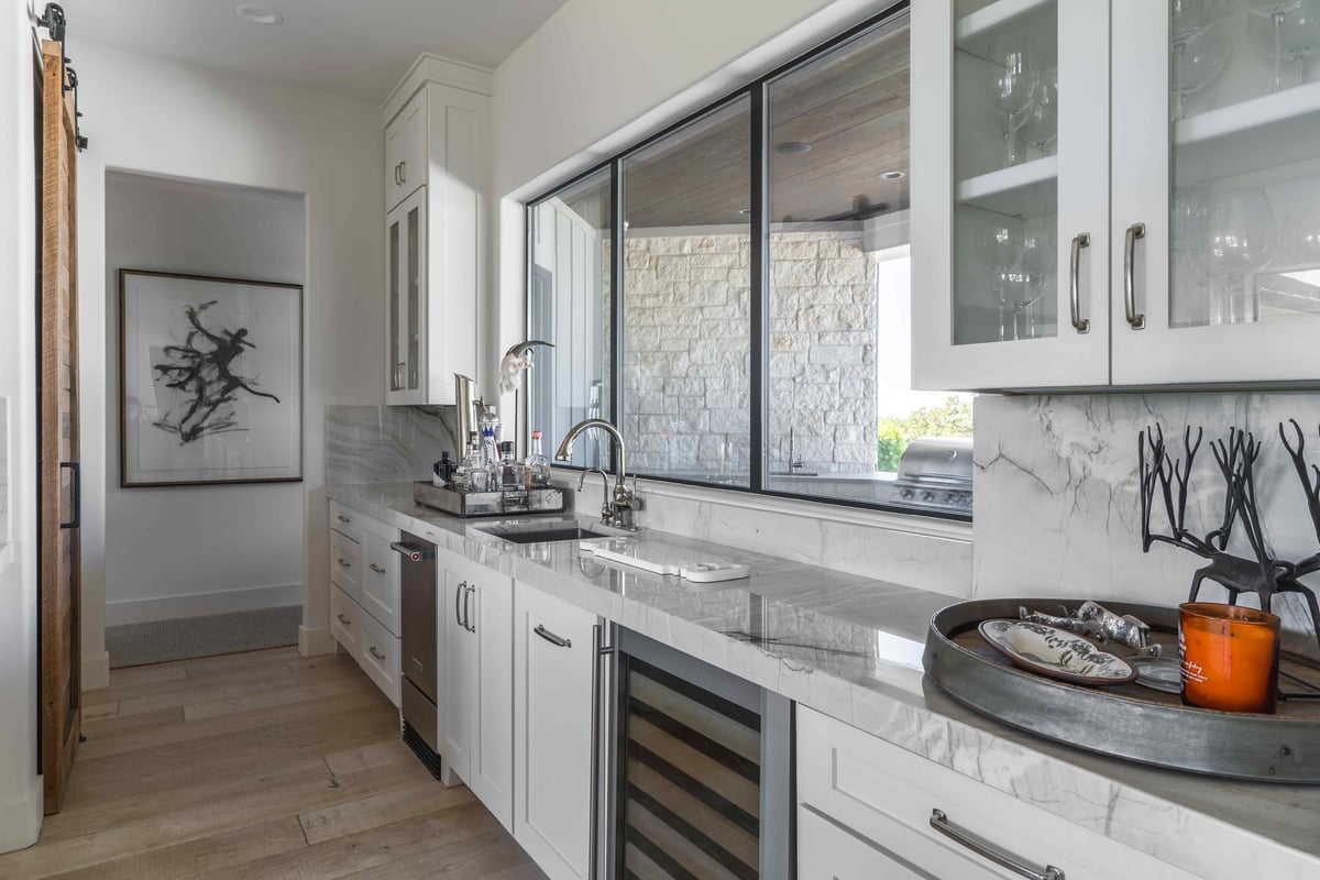 Kitchen with large windows, modern appliances, and gray marble countertops | J Bryant Boyd