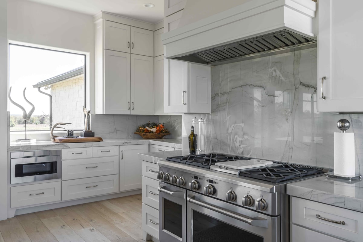 Kitchen with white cabinets and large modern oven | J Bryant Boyd