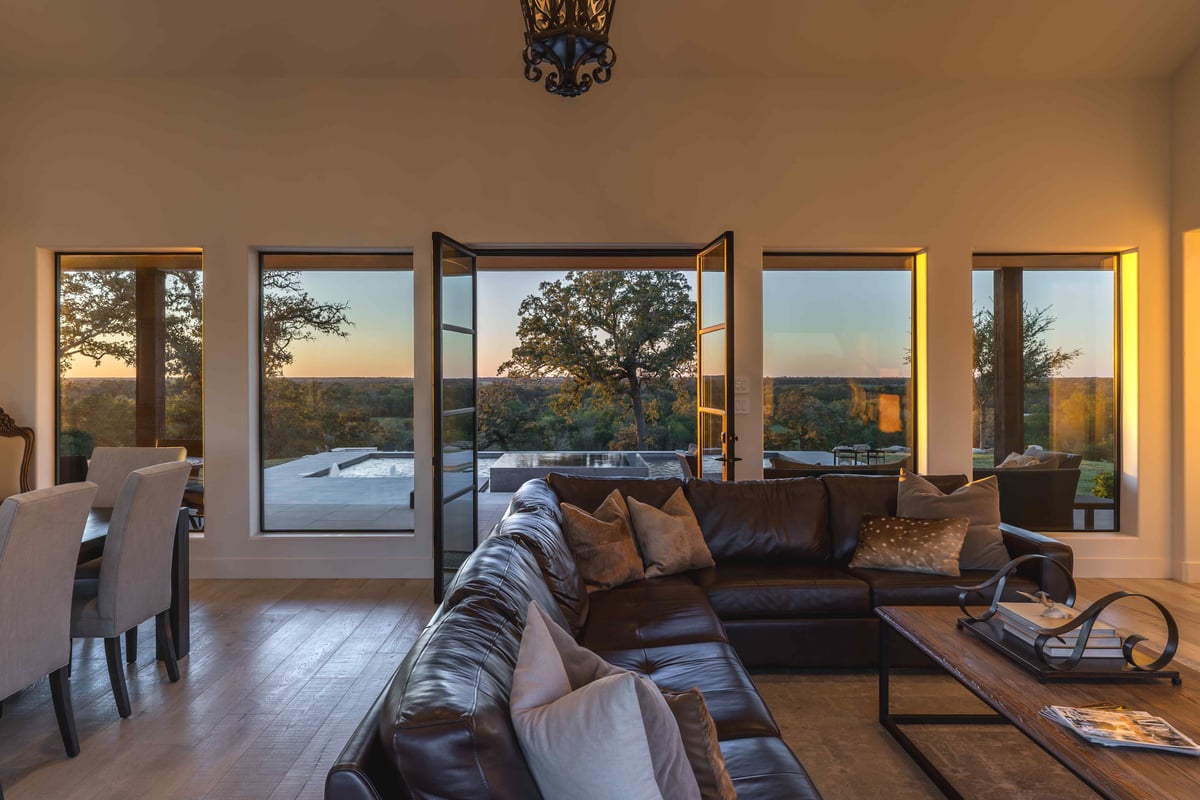 Large windows providing natural light and open glass doors into living area | J Bryant Boyd