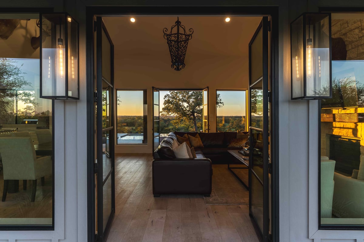 Open glass doors on both sides of modern Texas home showing view of the land on each side | J Bryant Boyd