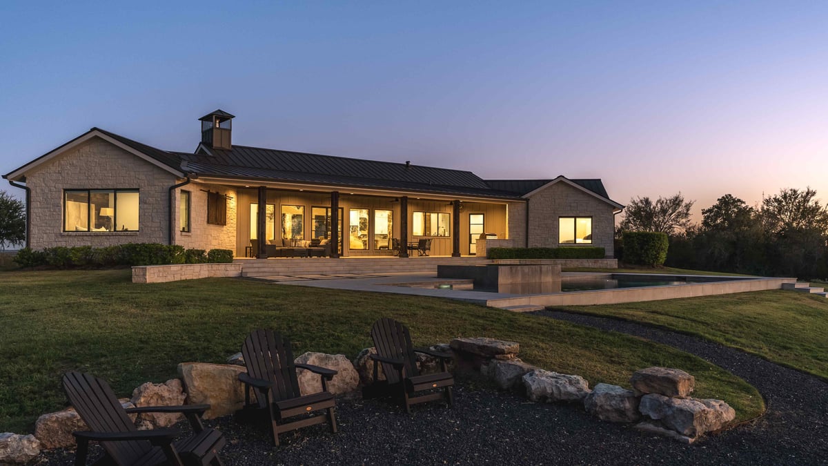 Side exterior of central Texas home with large windows and stone landscaping | J Bryant Boyd