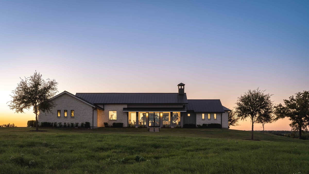 Sun setting on modern central Texas home next to trees | J Bryant Boyd