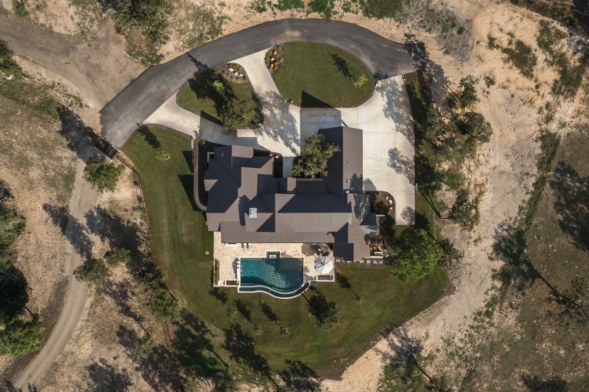 Aerial view of a large house with a pool and surrounding landscape in central Texas | J Bryant Boyd