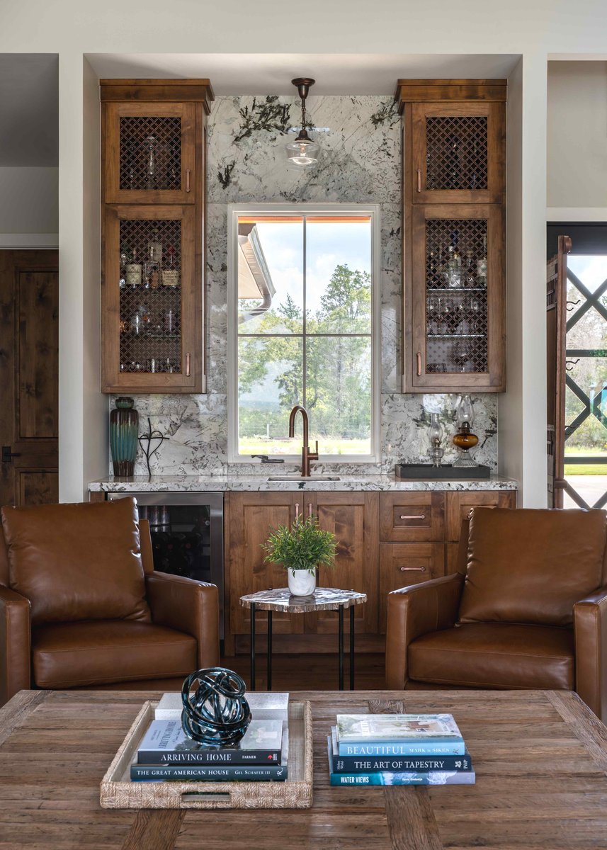 Cozy seating area with built-in cabinets, a window, and leather chairs in central Texas | J Bryant Boyd