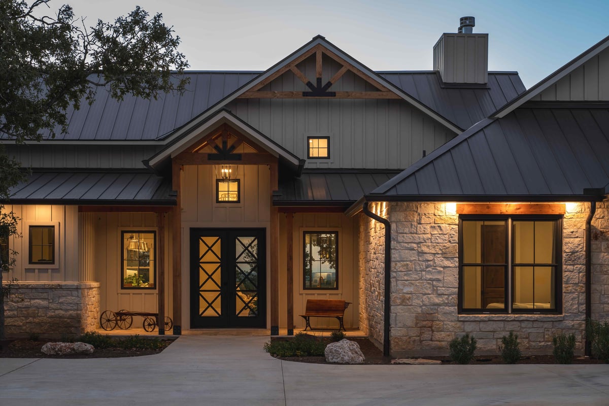 House entrance with a stone and wood exterior, lit up at dusk in central Texas | J Bryant Boyd