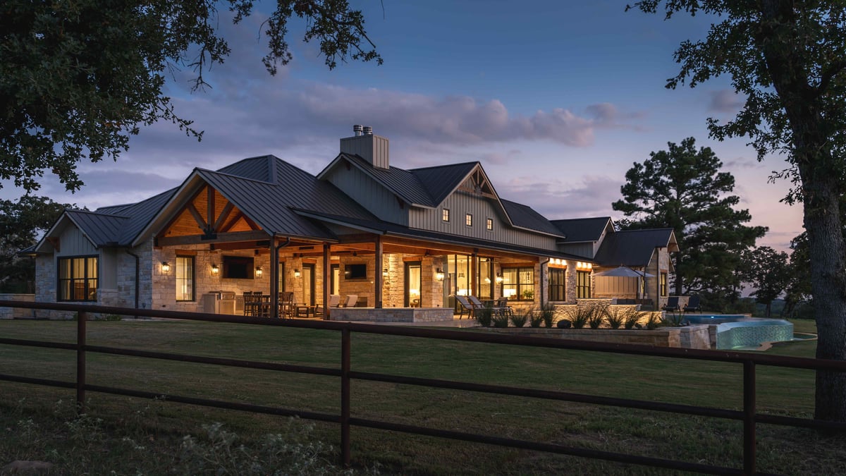 House exterior with a covered patio, lit up at dusk in central Texas | J Bryant Boyd