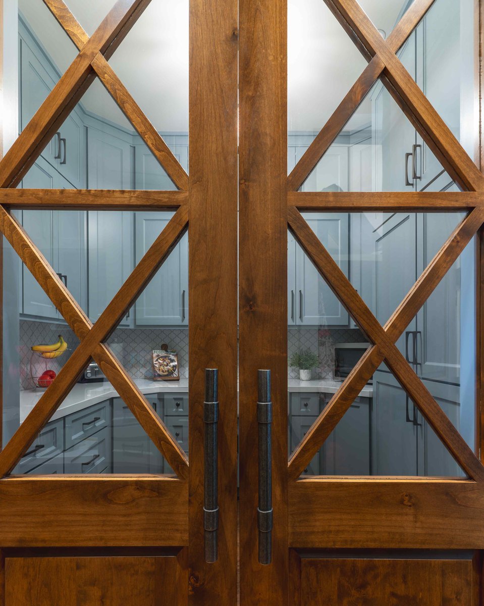 Kitchen viewed through wooden double doors with glass panels | J Bryant Boyd