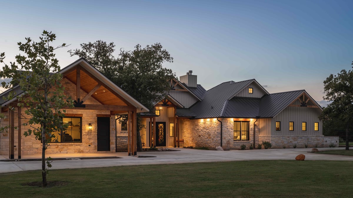 Modern farmhouse with stone exterior and warm lighting | J Bryant Boyd