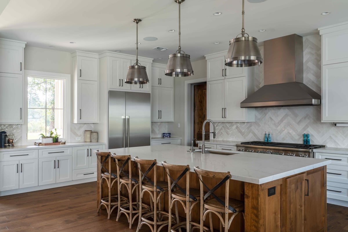 Modern kitchen with a large island, stainless steel appliances, and pendant lights in central Texas | J Bryant Boyd