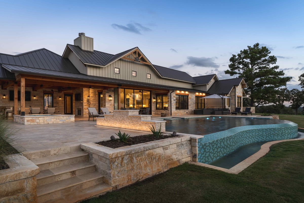 Patio with seating and dining areas, illuminated at night in central Texas | J Bryant Boyd