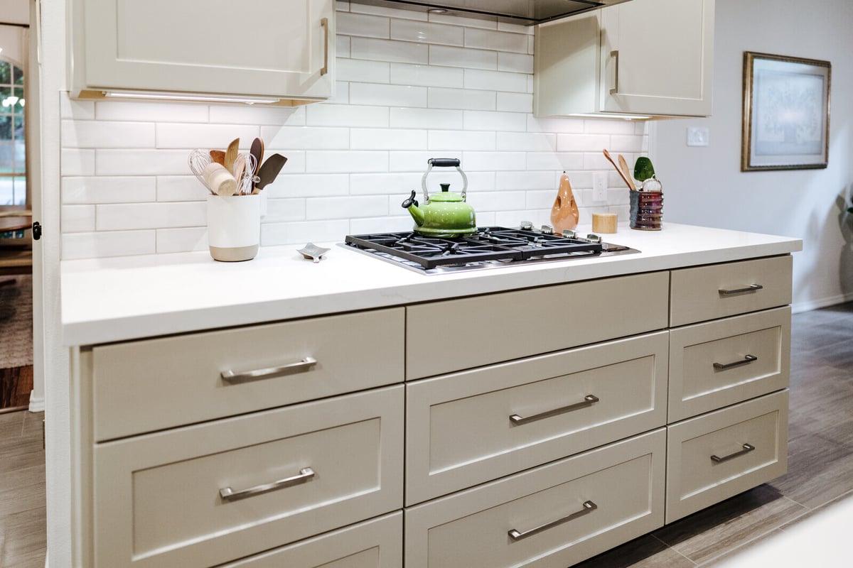 Close-up of a kitchen island with stainless steel range and modern decor in Georgetown, TX by J Bryant Boyd