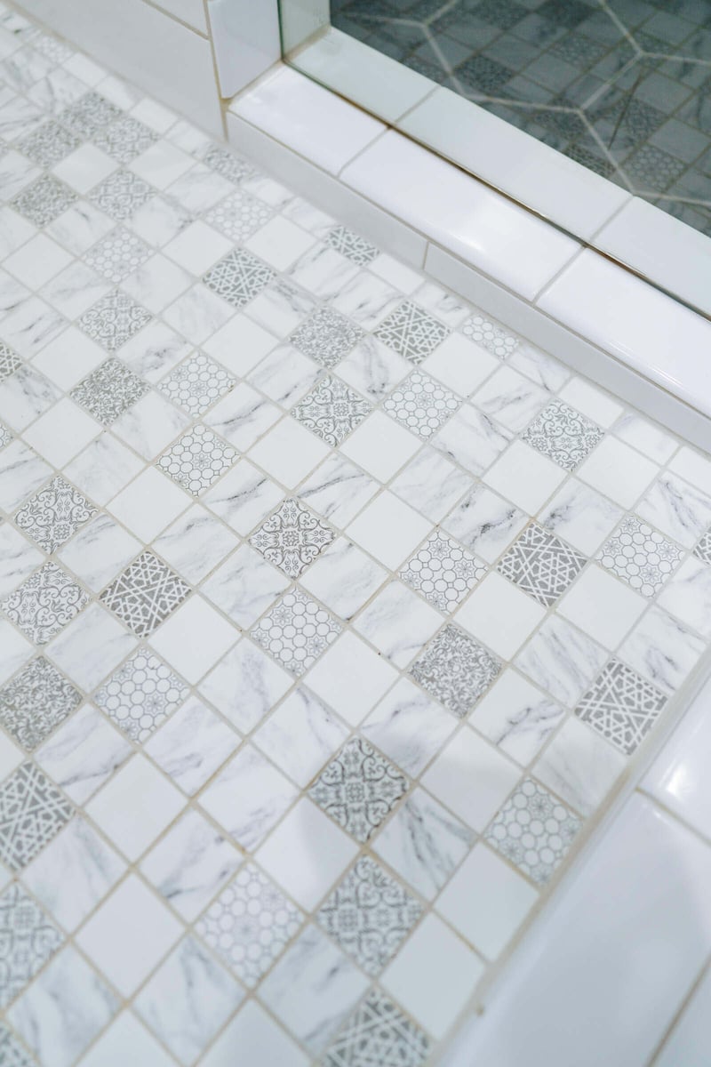 Close-up of intricately designed mosaic tile flooring in a Georgetown, TX bathroom remodel by J Bryant Boyd