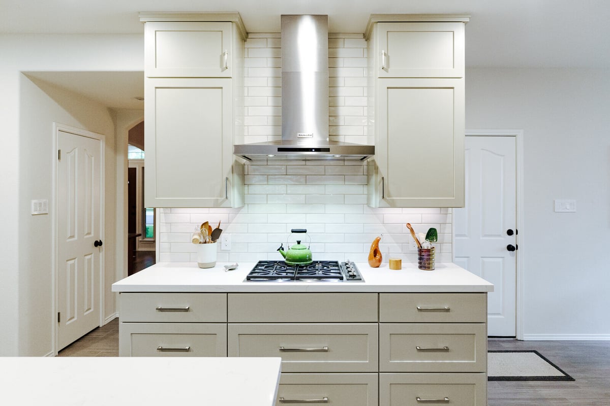 Elegant kitchen remodel with subway tile backsplash and stainless steel range hood in Georgetown, TX by J Bryant Boyd