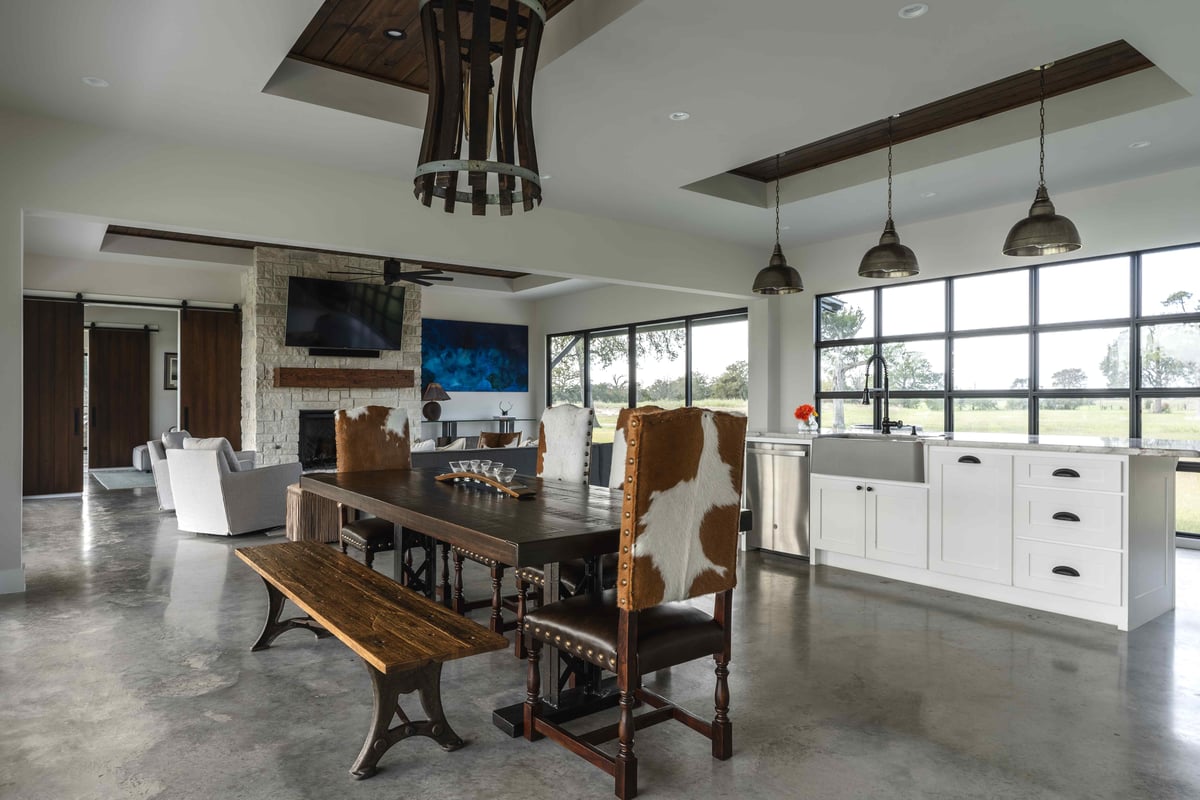 Contemporary living room with a stone fireplace, grey sofa, and wooden accents. | J Bryant Boyd