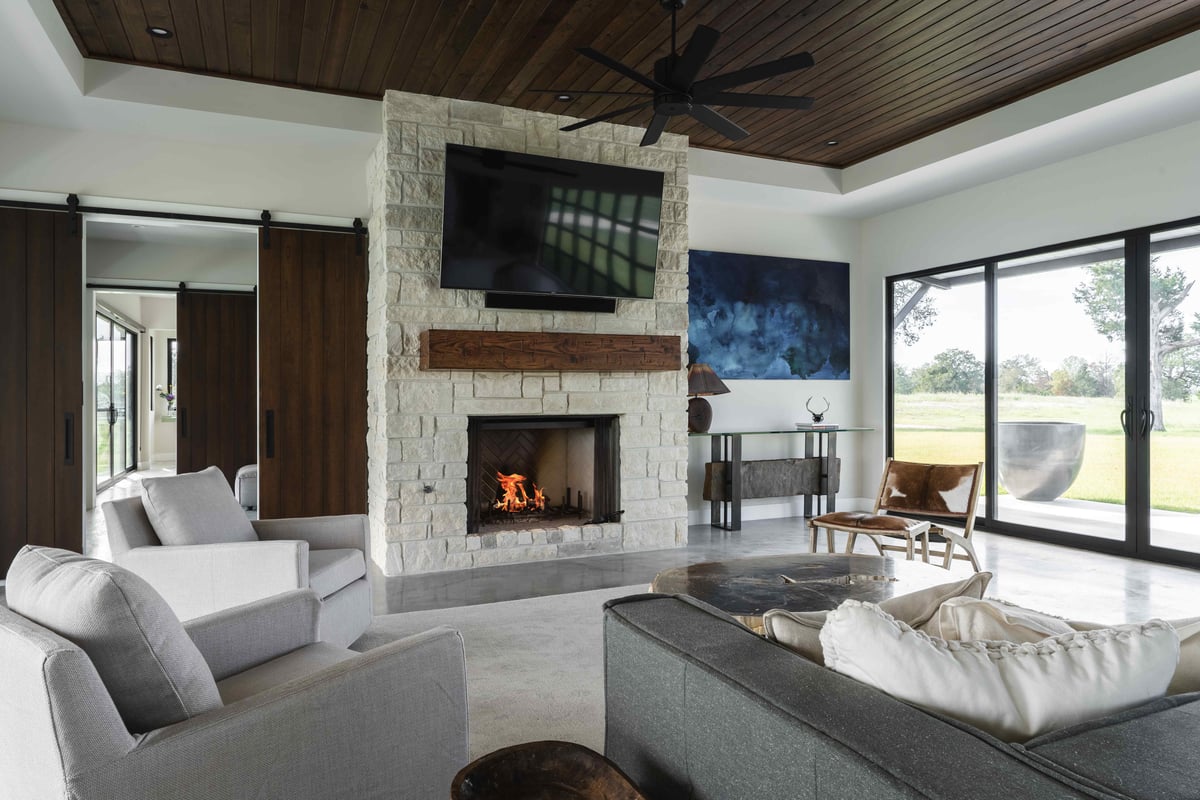 Modern living room with tv and stone fireplace | J Bryant Boyd