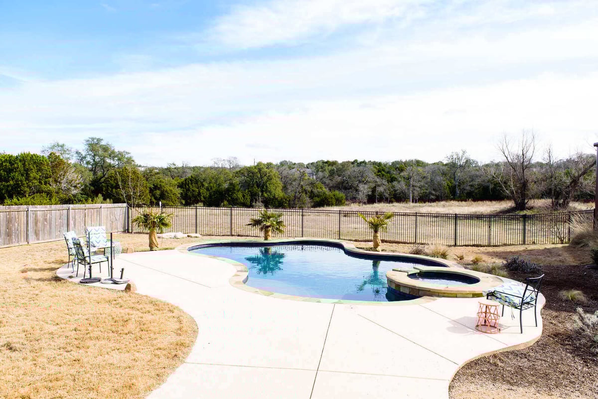 Back patio with stone facade and outdoor seating in a Georgetown, TX custom home by J Bryant Boyd Design-Build
