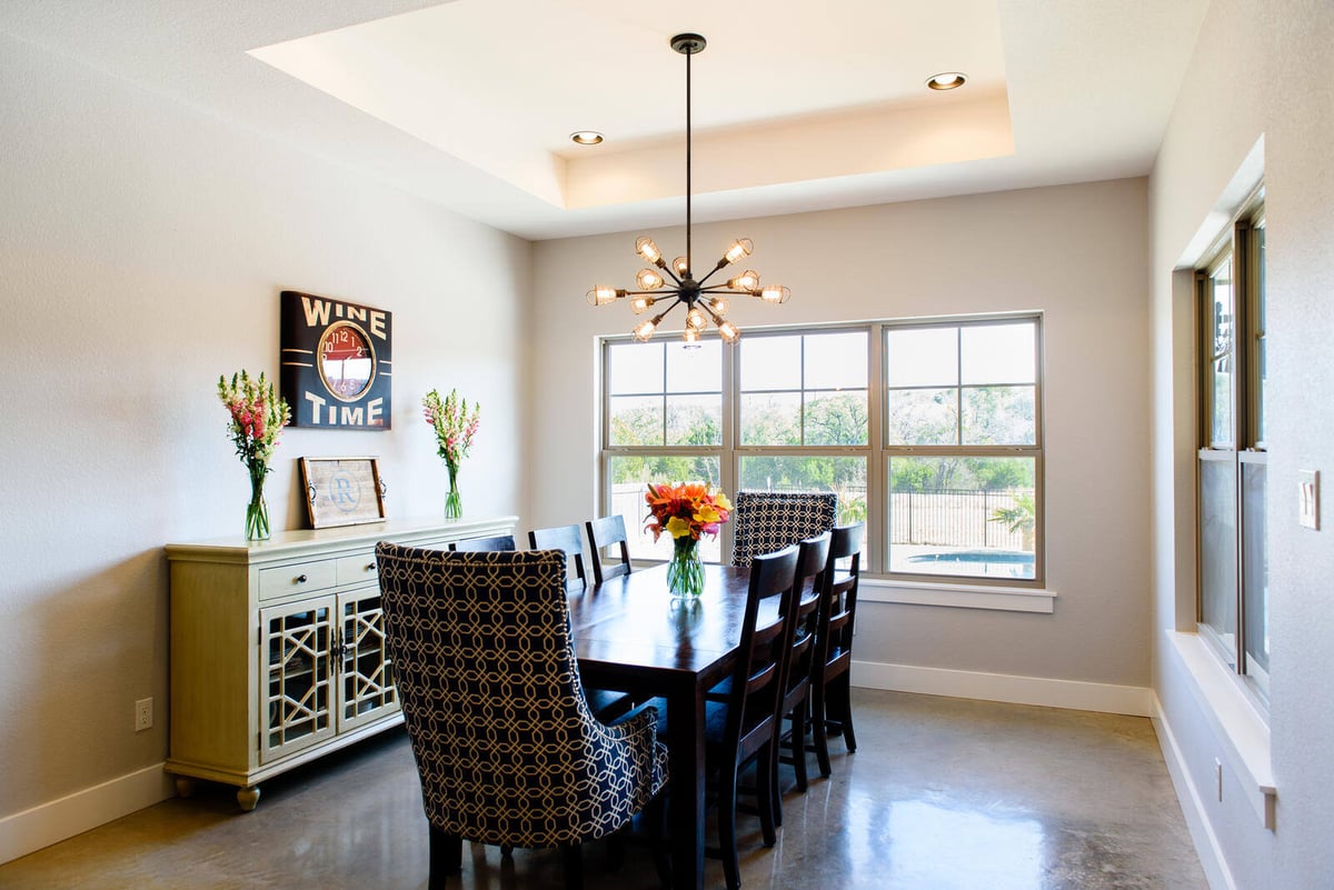 Dining room featuring modern chandelier and bright natural light, remodeled by J. Bryant Boyd in Georgetown, TX