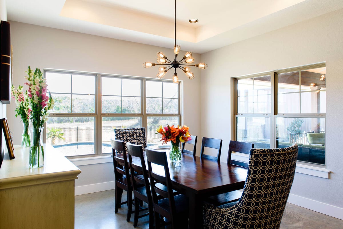 Dining room with unique chandelier and large windows, remodeled by J. Bryant Boyd in Georgetown, TX