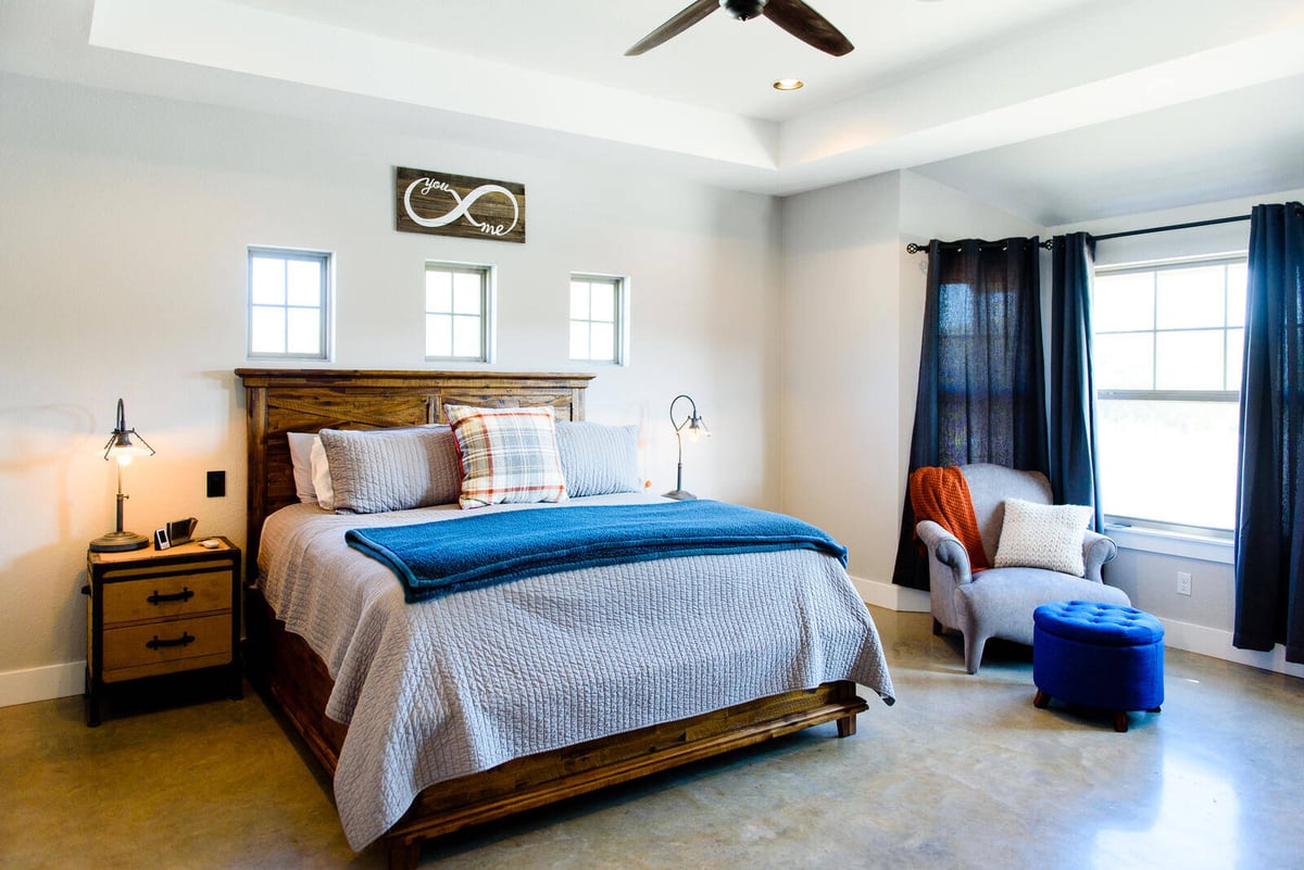 Master bedroom with wooden bed frame and modern ceiling fan in a Georgetown, TX custom home by J Bryant Boyd Design-Build