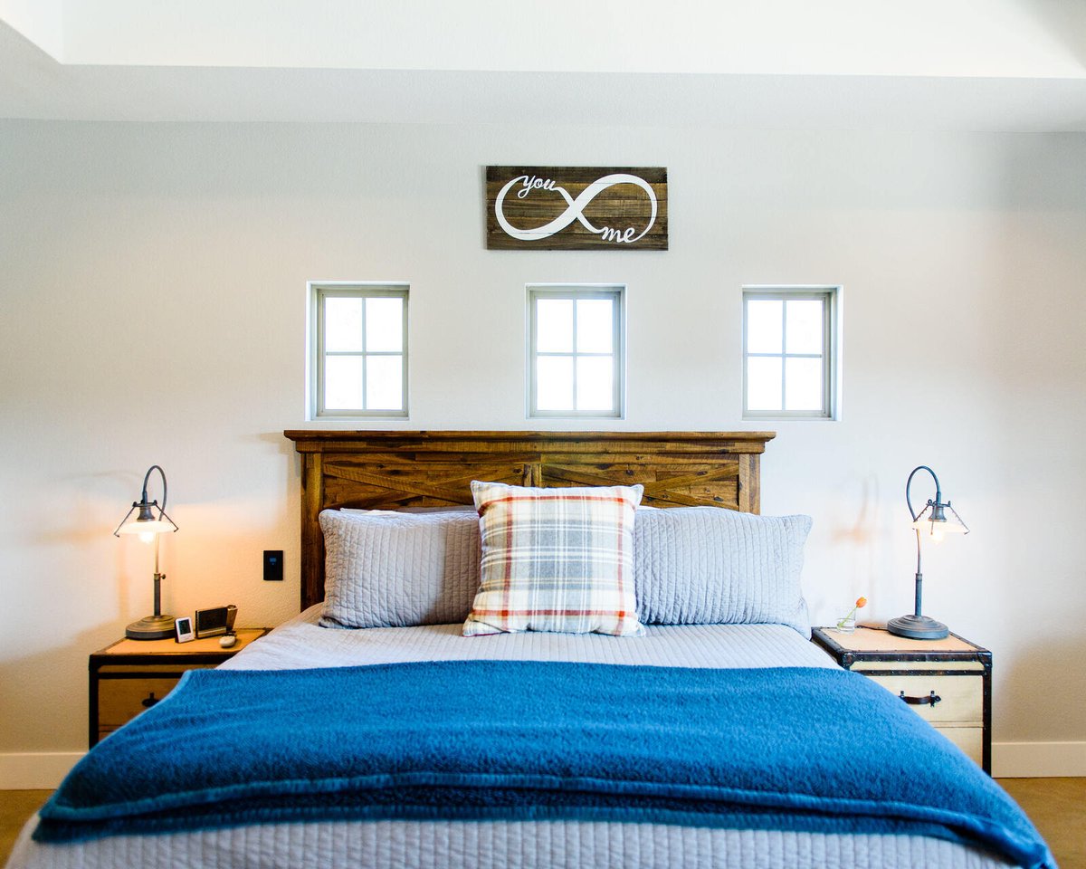 Modern master bedroom with stylish decor and infinity symbol wall art in Georgetown, TX by J Bryant Boyd Design-Build