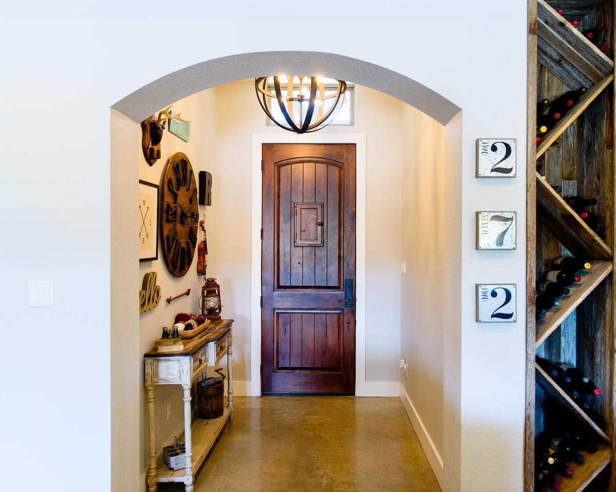 Rustic entryway with vintage decor and custom wine rack, remodeled by J. Bryant Boyd in Georgetown, TX