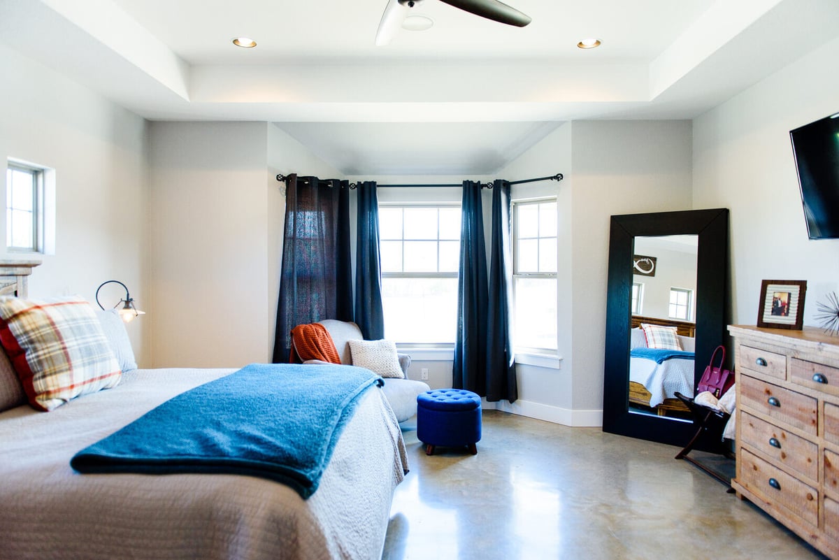 Spacious master bedroom with large windows and modern decor in a Georgetown, TX custom home by J Bryant Boyd Design-Build