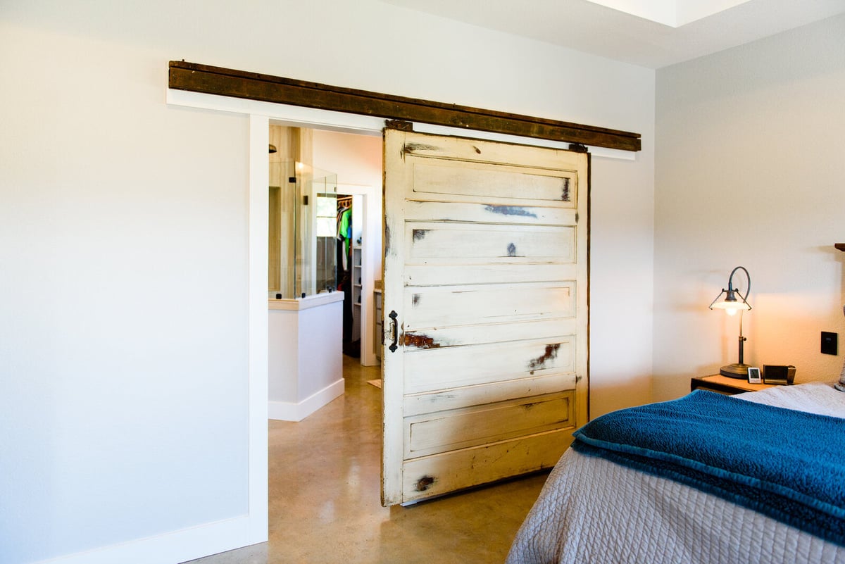 Vintage sliding barn door leading to the bathroom in a Georgetown, TX home by J Bryant Boyd Design-Build
