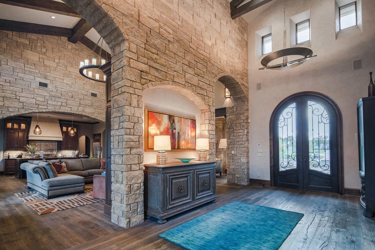 Cozy living room with fireplace and tall windows in a custom home by J Bryant Boyd in Georgetown, TX