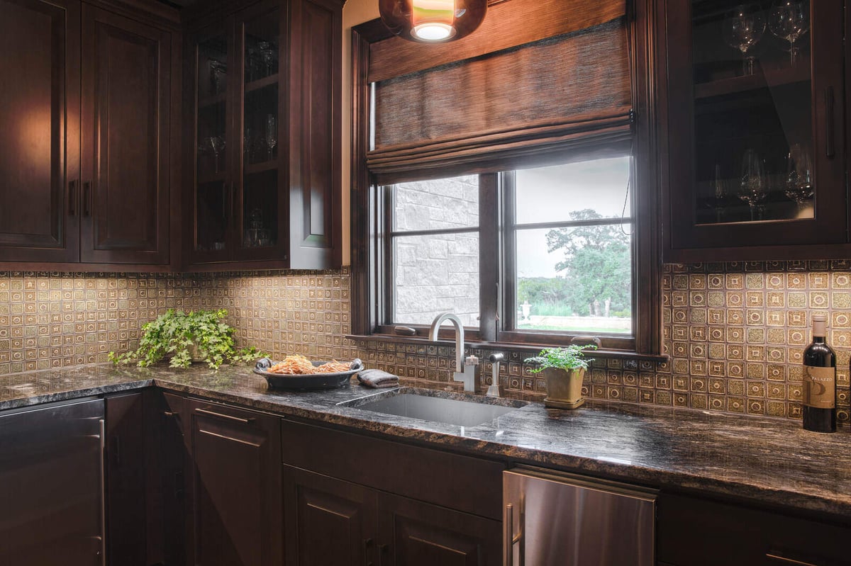 Custom home bar area with dark wood cabinetry and granite countertops by J Bryant Boyd, Georgetown, TX