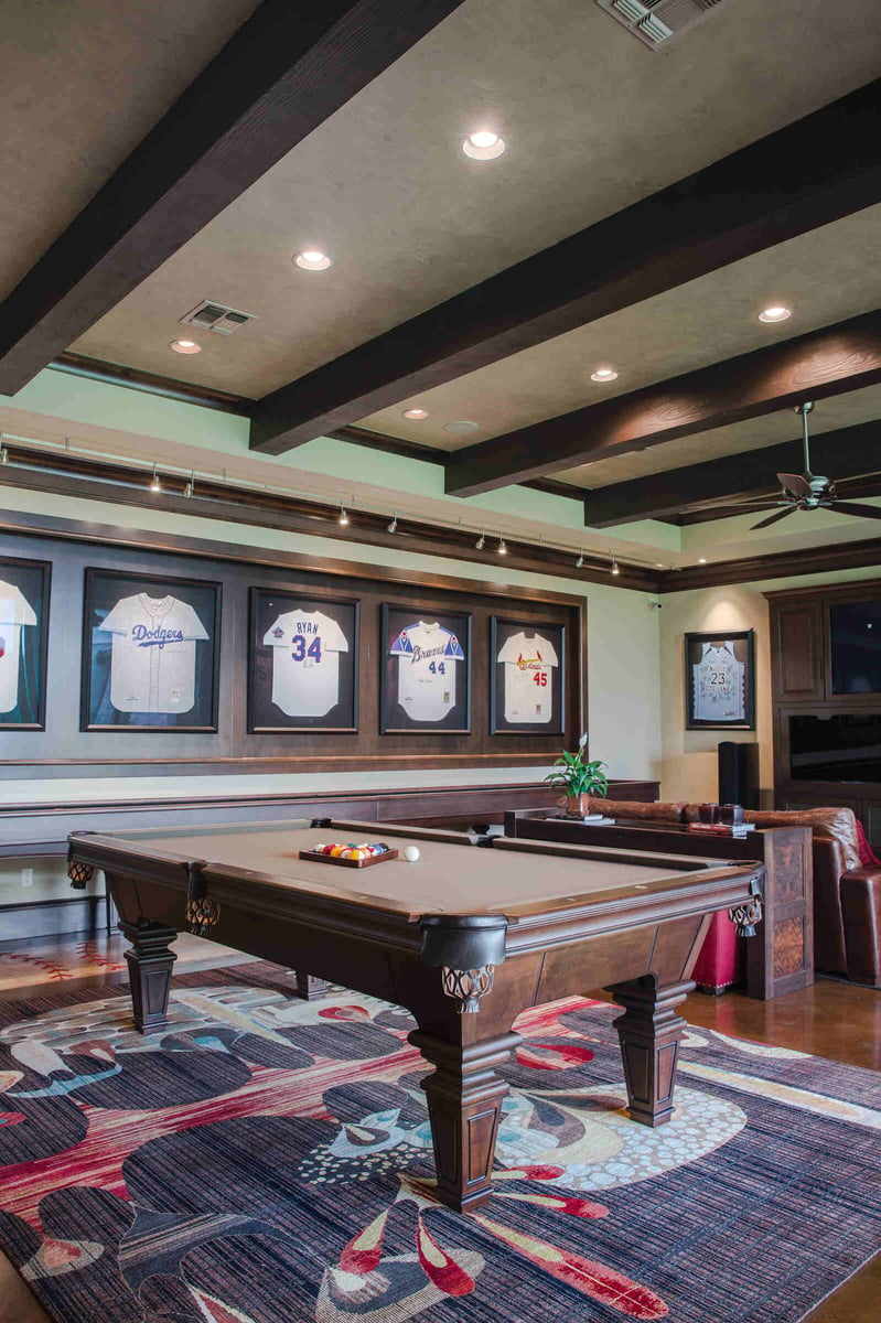 Custom home game room with a pool table and entertainment area by J Bryant Boyd in Georgetown, TX