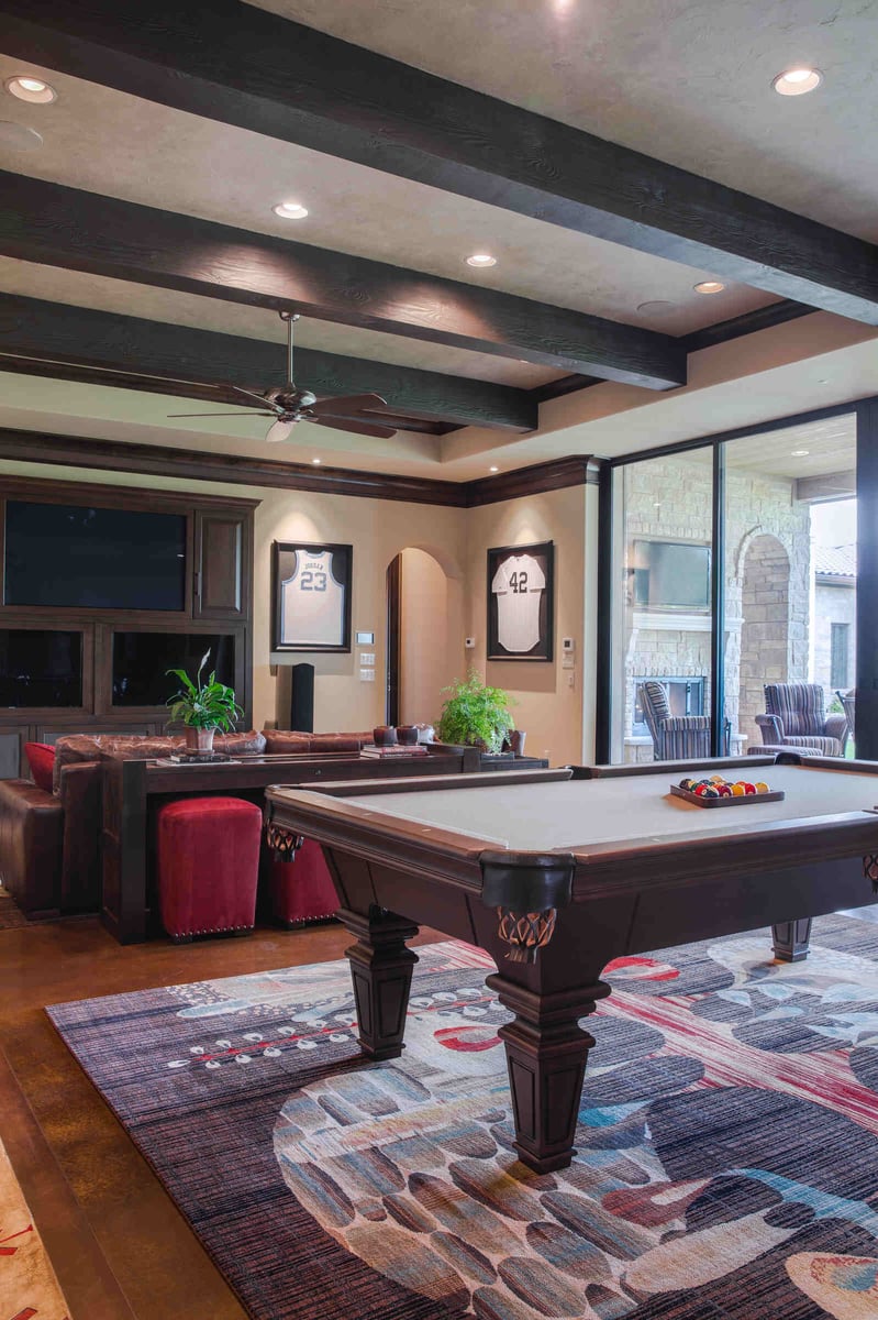 Custom home game room with pool table and framed sports jerseys by J Bryant Boyd in Georgetown, TX