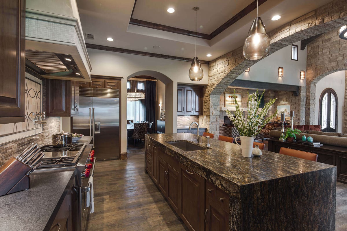 Custom kitchen with stainless steel appliances and granite island in a J Bryant Boyd home in Georgetown, TX