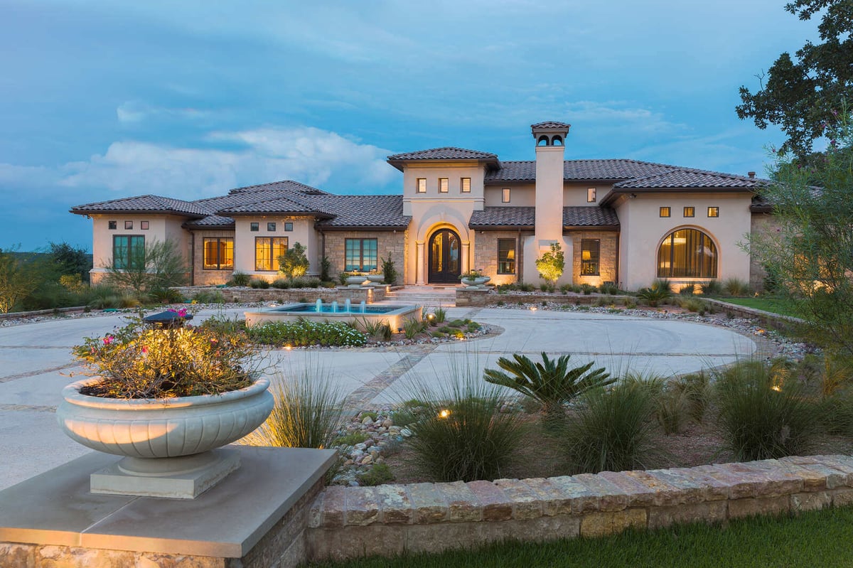 Expansive luxury home exterior with well-lit entrance and landscaping by J Bryant Boyd in Georgetown, TX