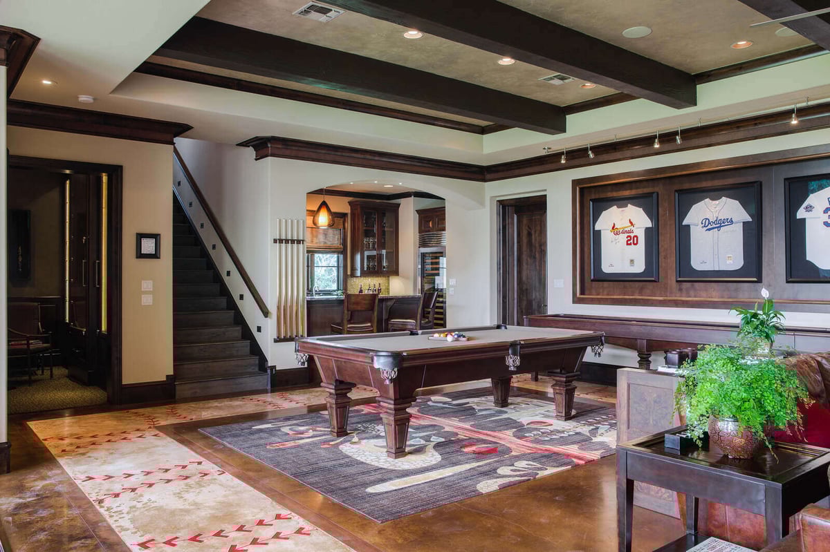 Game room with a pool table and sports memorabilia in a custom home by J Bryant Boyd in Georgetown, TX