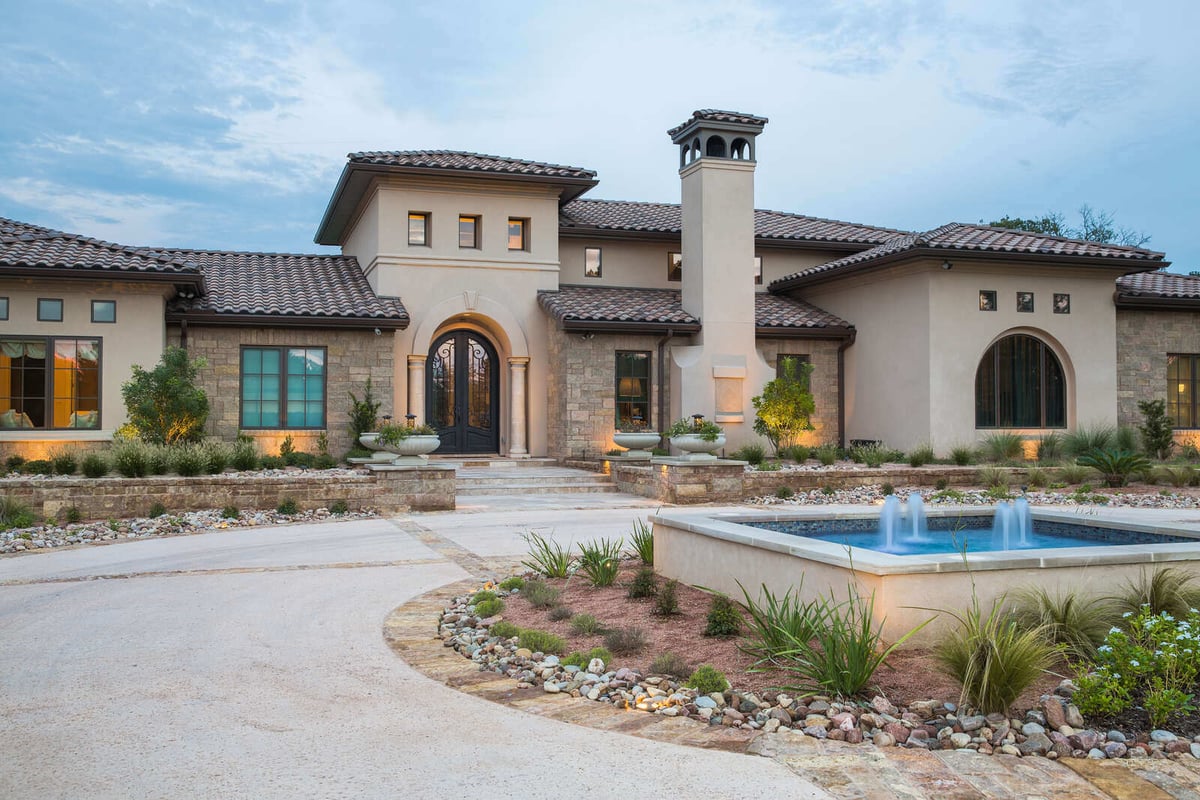 Grand entrance to a custom stone home with fountain in the front yard by J Bryant Boyd in Georgetown, TX