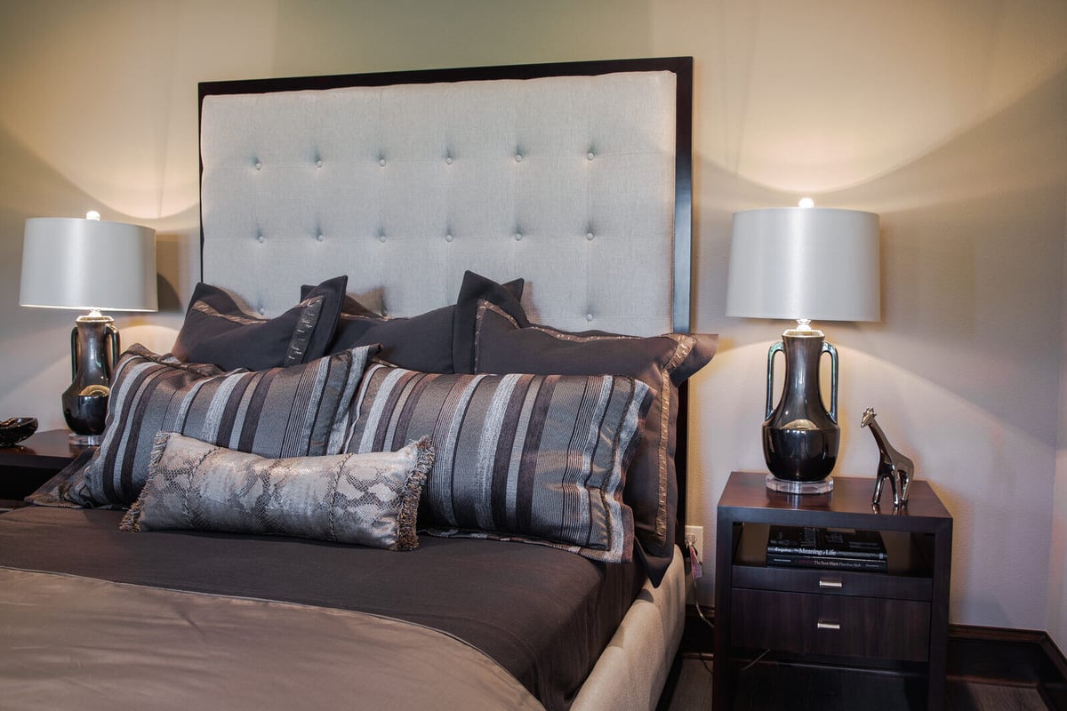 Luxurious bedroom with upholstered headboard and modern decor in a custom home by J Bryant Boyd, Georgetown, TX
