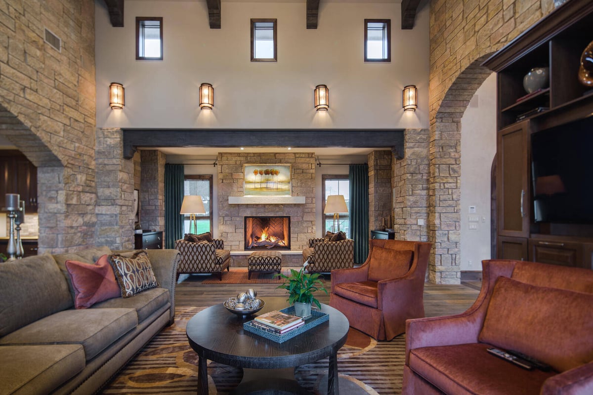 Luxurious outdoor patio with stone columns and lush greenery in a custom home by J Bryant Boyd in Georgetown, TX