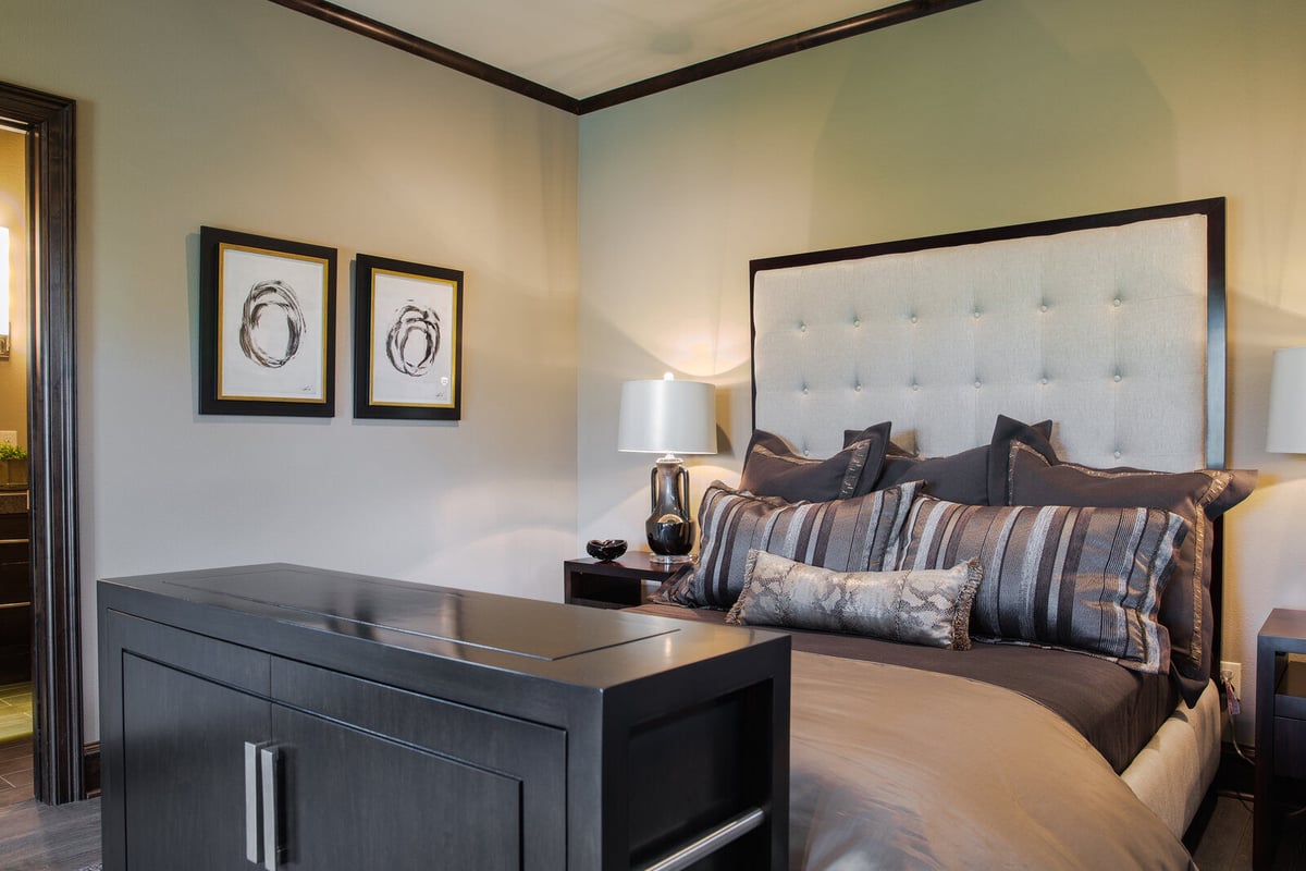 Modern bedroom design in a custom home by J Bryant Boyd in Georgetown, TX, highlighting artistic wall pieces and a sophisticated dresser