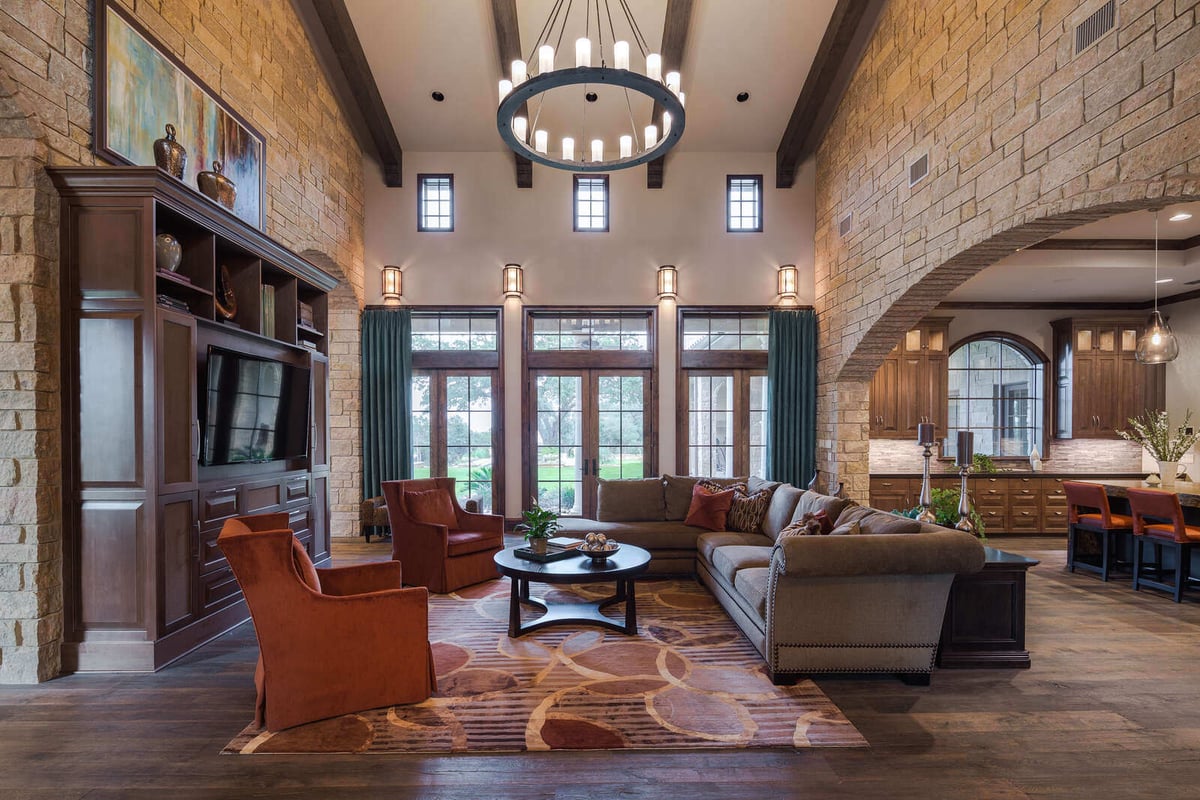 Open living space with a large sectional and view into the custom kitchen by J Bryant Boyd in Georgetown, TX