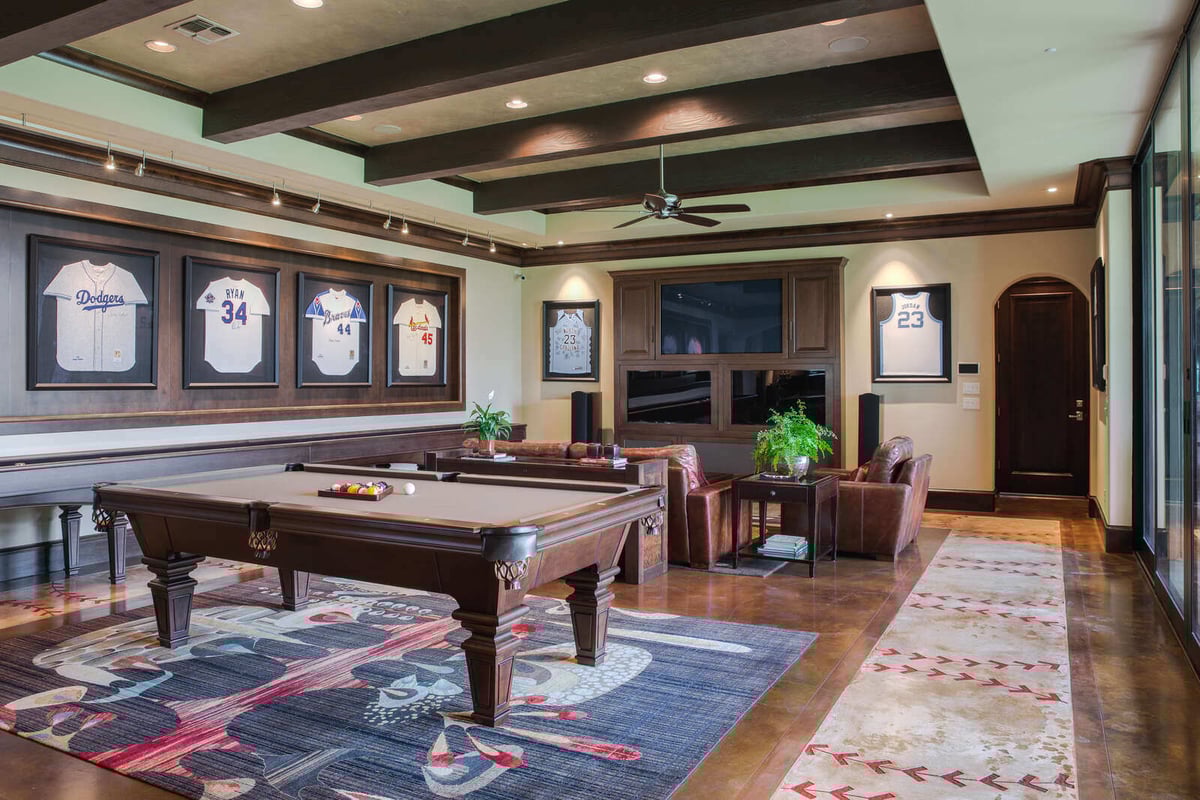 Spacious custom home game room with pool table and sports memorabilia by J Bryant Boyd in Georgetown, TX