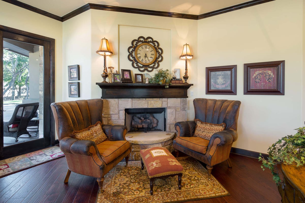 Custom home living area with fireplace and armchairs by J Bryant Boyd in Georgetown, TX