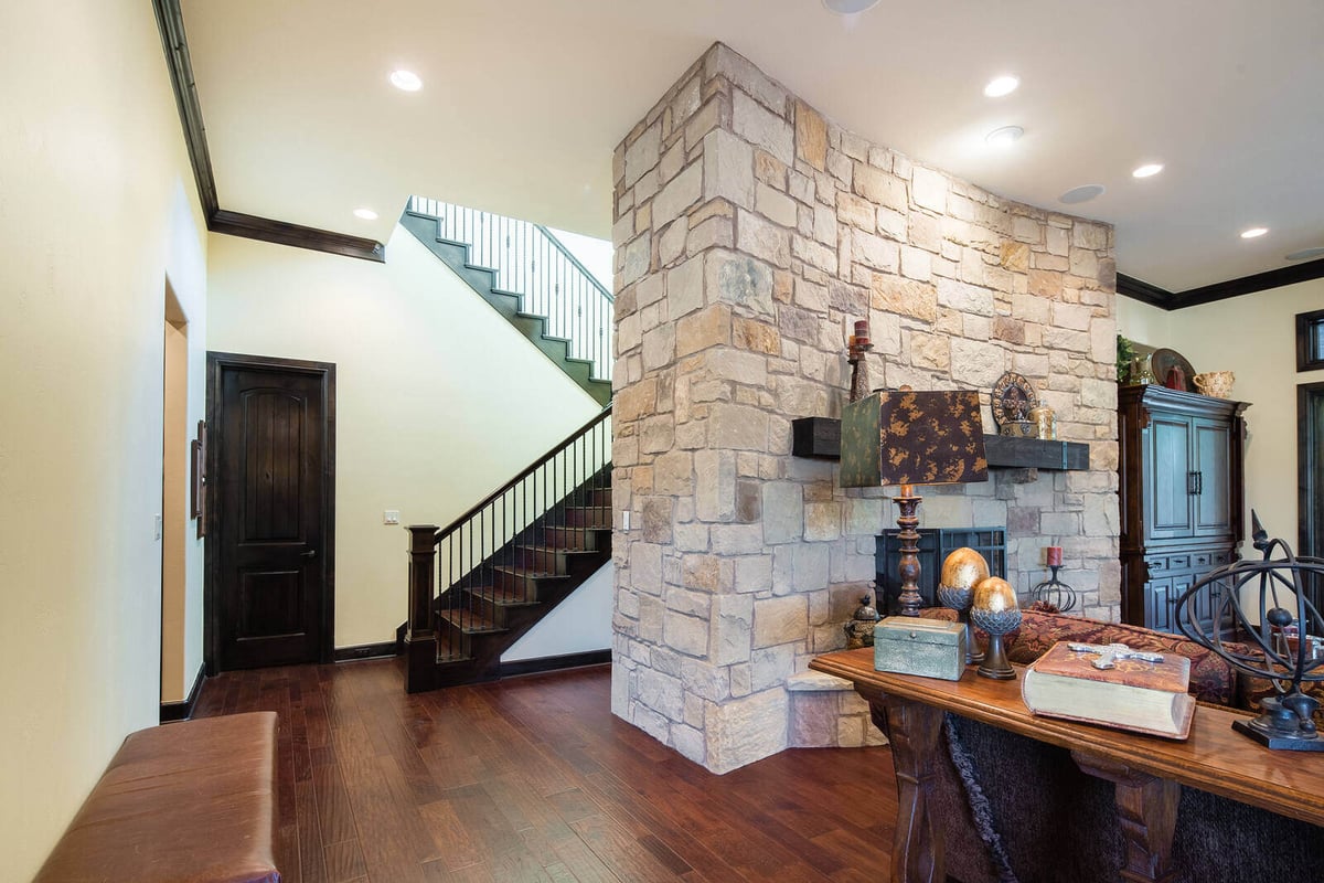 Staircase and stone wall in a custom home by J Bryant Boyd in Georgetown, TX