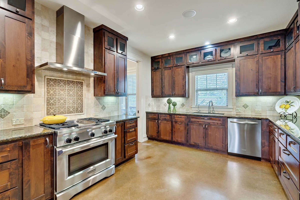 Bright and spacious kitchen with large windows and pendant lighting in a custom home by J Bryant Boyd, Georgetown, TX