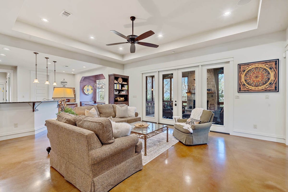 Comfortable living room with large windows and custom cabinetry by J Bryant Boyd in Georgetown, TX