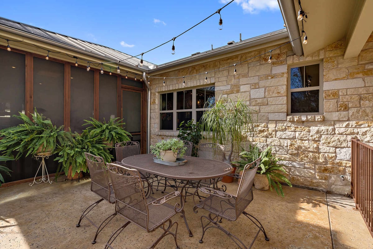 Covered patio with ceiling fan and grill in a custom Georgetown, TX home by J Bryant Boyd